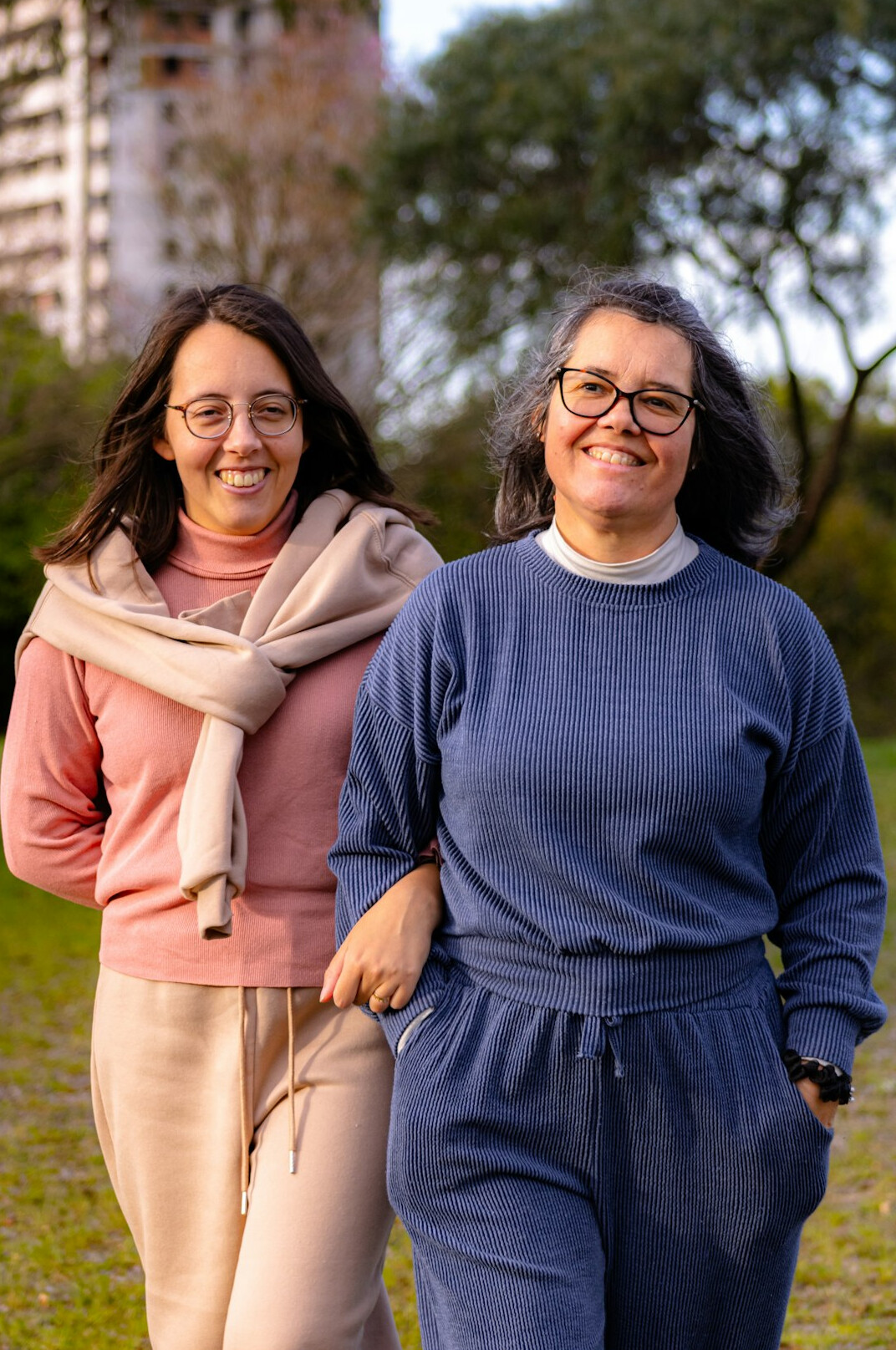 Adult daughter and senior mother smiling together outdoors